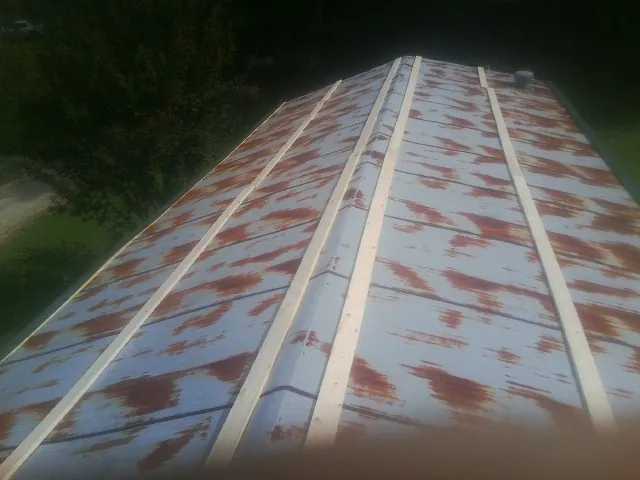 Rusted metal roof panels with new wood purlins before replacement — Storm Damage Roof Repair in Patrick Air Force Base by Roofing Brothers
